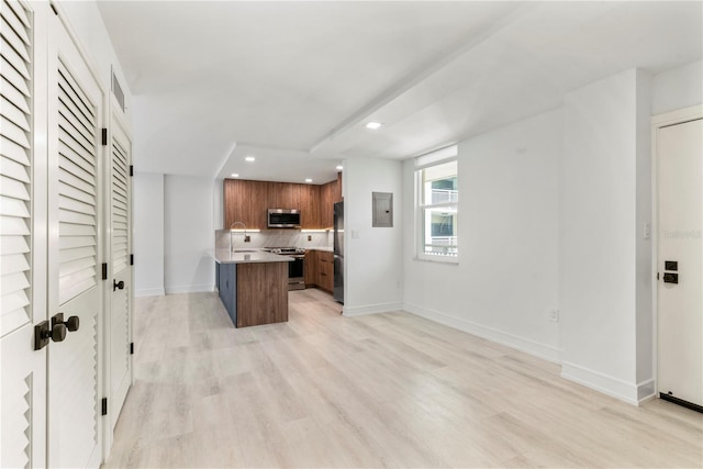 kitchen with baseboards, light wood-style flooring, backsplash, and appliances with stainless steel finishes