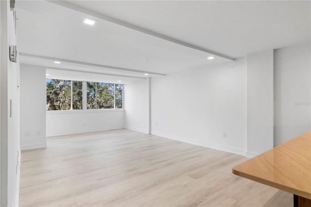 spare room with baseboards, light wood finished floors, and recessed lighting