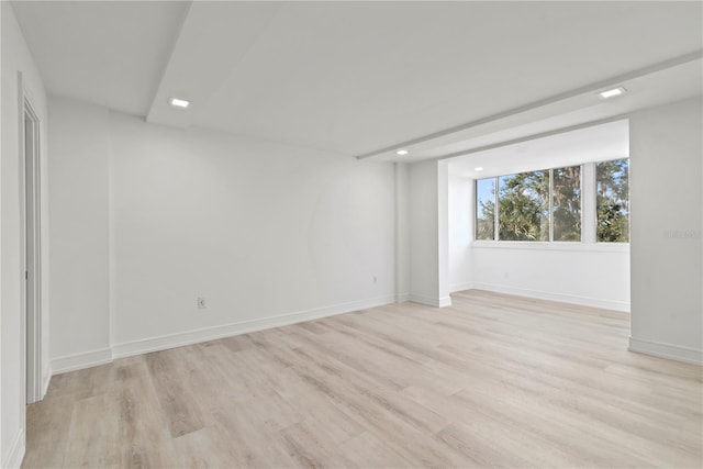 spare room featuring baseboards and light wood-style flooring