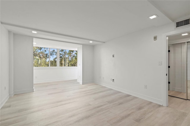 unfurnished room with baseboards, visible vents, and light wood-type flooring
