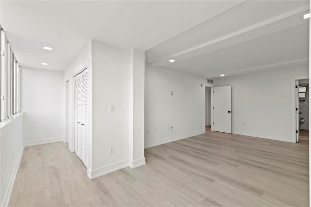 empty room featuring baseboards, light wood-style flooring, and recessed lighting