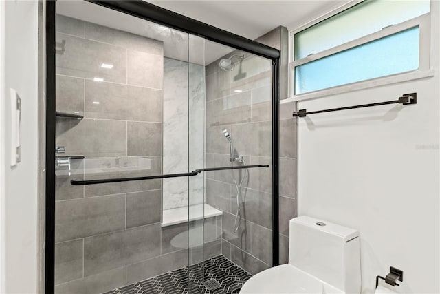 bathroom with a shower stall and toilet