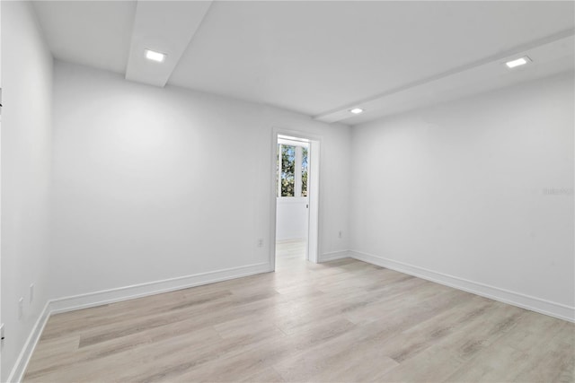 empty room with baseboards, recessed lighting, and light wood-type flooring