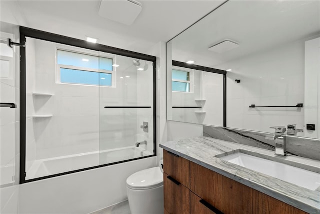 full bathroom featuring toilet, vanity, and shower / bath combination with glass door