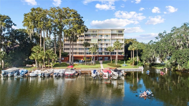 view of dock with a water view and a yard