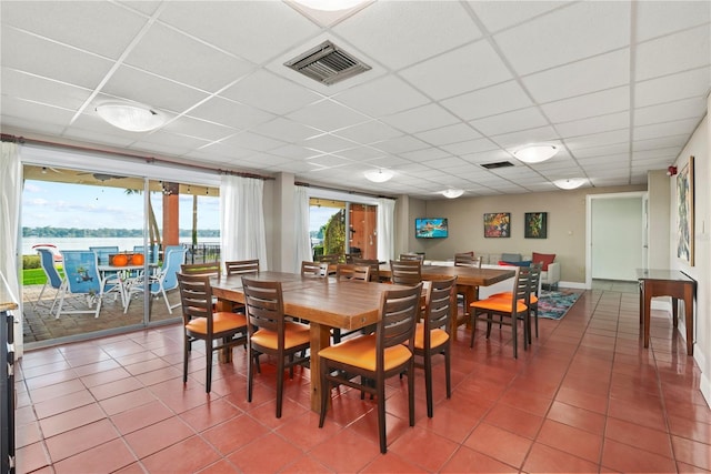 tiled dining space with a paneled ceiling and visible vents