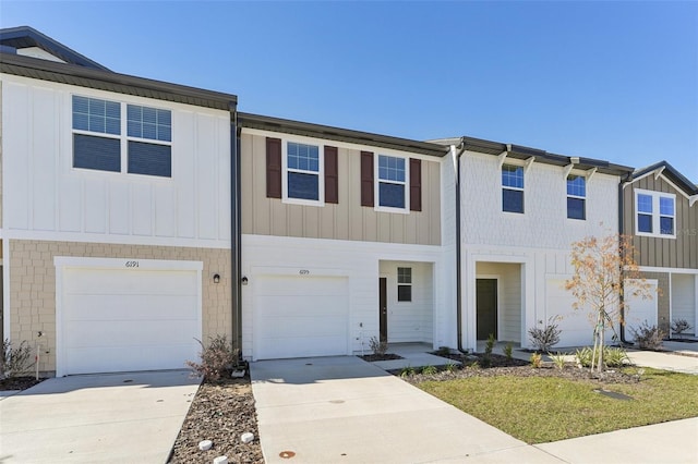multi unit property with driveway, an attached garage, and board and batten siding