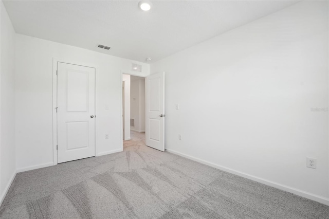 unfurnished bedroom featuring carpet floors, baseboards, and visible vents