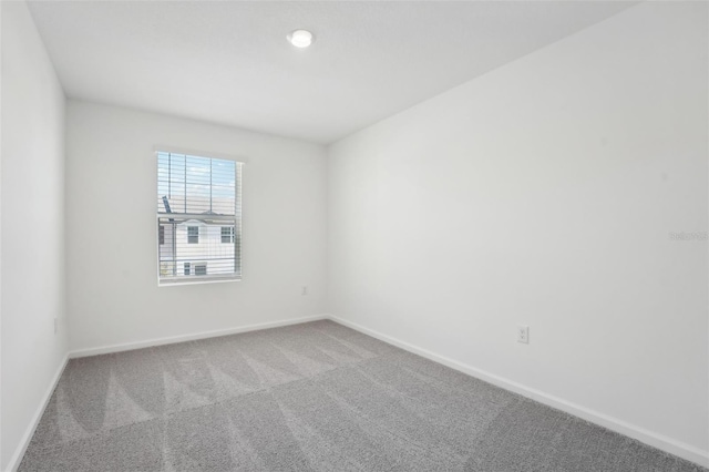 empty room featuring baseboards and carpet flooring