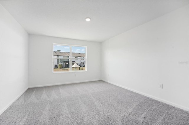 carpeted spare room featuring baseboards
