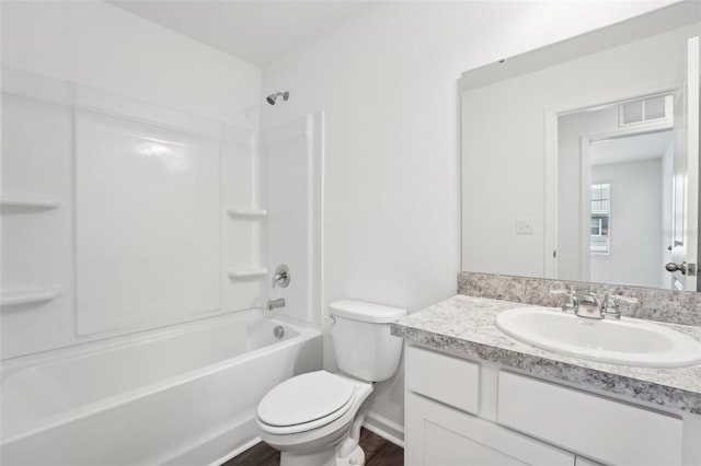 full bathroom with visible vents, washtub / shower combination, toilet, wood finished floors, and vanity