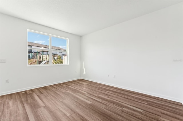 unfurnished room with baseboards and wood finished floors