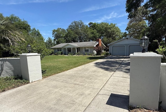 12015 SE 72nd Court Rd, Belleview, FL 34420 - single story home with driveway, a front yard, an outbuilding, and a detached garage