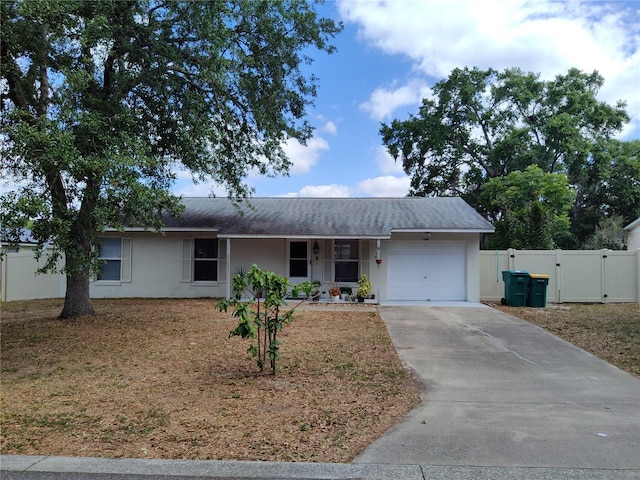 ranch-style home featuring a garage, fence, stucco siding, a gate, and concrete driveway