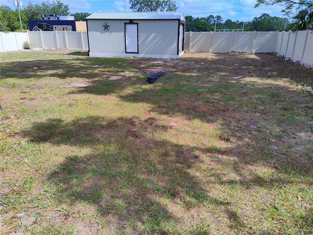 view of yard with a fenced backyard, an outbuilding, and a shed
