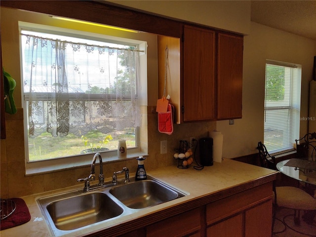 kitchen featuring a sink, light countertops, and brown cabinets