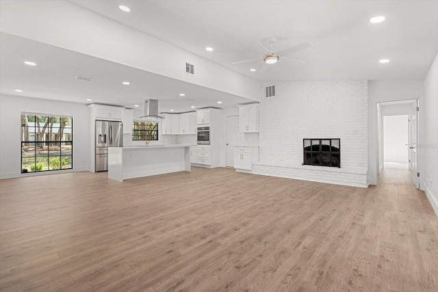 345 W Hornbeam Dr, Longwood, FL 32779 - unfurnished living room with visible vents, a ceiling fan, light wood finished floors, and a fireplace