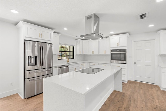 345 W Hornbeam Dr, Longwood, FL 32779 - kitchen with white cabinets, appliances with stainless steel finishes, a sink, island exhaust hood, and visible vents