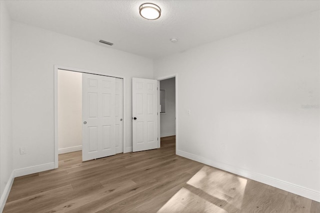 4246 Clarinda St, Orlando, FL 32811 - unfurnished bedroom with a closet, baseboards, visible vents, and wood finished floors