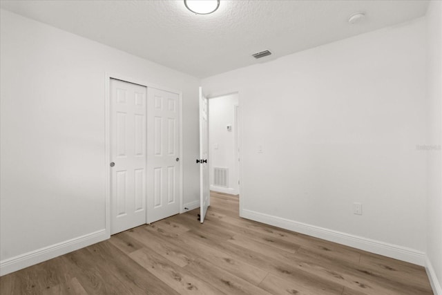 4246 Clarinda St, Orlando, FL 32811 - unfurnished bedroom with baseboards, visible vents, a closet, and wood finished floors