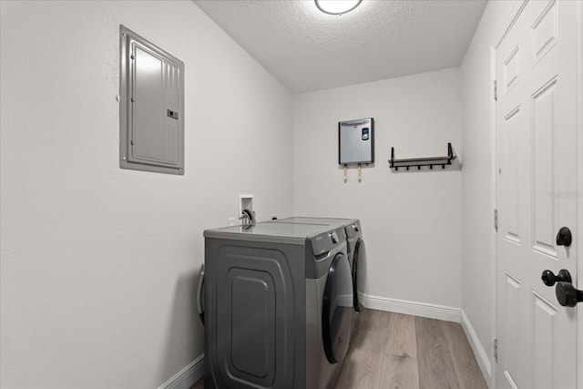 4246 Clarinda St, Orlando, FL 32811 - washroom featuring electric panel, wood finished floors, washing machine and clothes dryer, a textured ceiling, and laundry area
