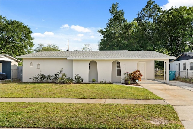 4246 Clarinda St, Orlando, FL 32811 - view of front of home featuring concrete driveway, stucco siding, fence, and a front lawn