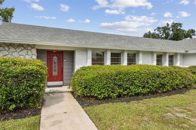 3994 Irma Shores Dr, Orlando, FL 32817 - view of exterior entry with stucco siding and a shingled roof