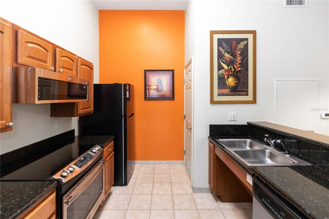 8100 Poinciana Blvd Unit 2109, Orlando, FL 32821 - kitchen featuring light tile patterned flooring, dark stone countertops, a sink, and appliances with stainless steel finishes