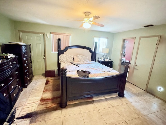 bedroom featuring visible vents, a ceiling fan, and light tile patterned floors