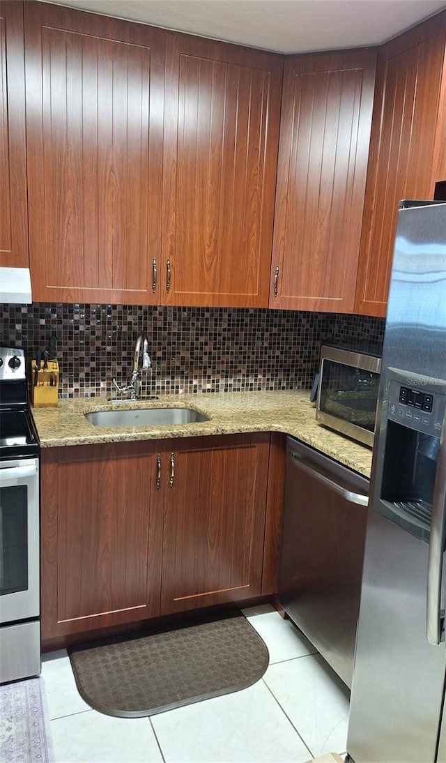 kitchen with appliances with stainless steel finishes, tasteful backsplash, a sink, ventilation hood, and light tile patterned flooring