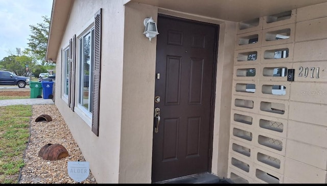 view of exterior entry featuring stucco siding
