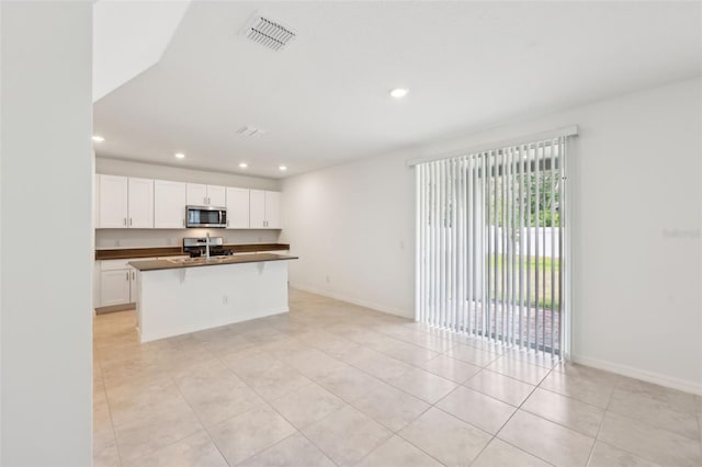 4705 Jasmine Cir, Leesburg, FL 34748 - kitchen featuring stainless steel appliances, dark countertops, white cabinetry, light tile patterned floors, and recessed lighting