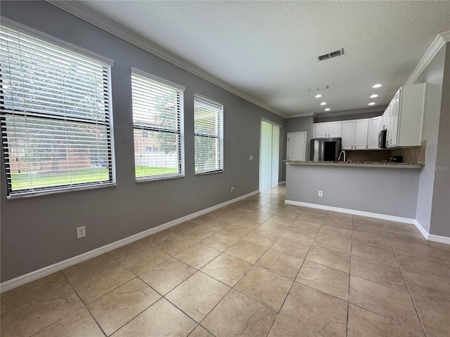 191 Chickasaw Berry Rd, Ocoee, FL 34761 - kitchen featuring stainless steel appliances, crown molding, light tile patterned floors, a textured ceiling, and healthy amount of natural light