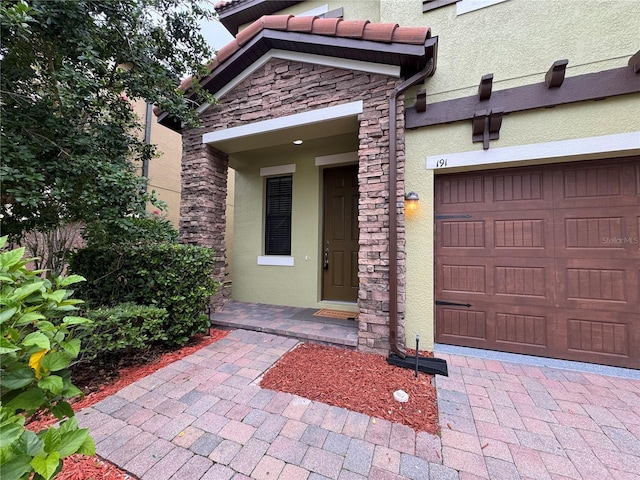 191 Chickasaw Berry Rd, Ocoee, FL 34761 - entrance to property featuring stucco siding, stone siding, and a garage
