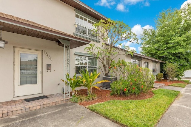 5763 Saint Christopher Dr Unit 55, Orlando, FL 32822 - doorway to property featuring cooling unit, stucco siding, and a balcony