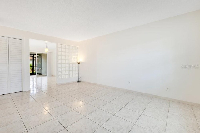 5763 Saint Christopher Dr Unit 55, Orlando, FL 32822 - unfurnished room with light tile patterned floors, baseboards, and a textured ceiling