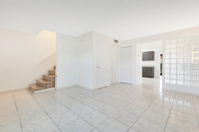 5763 Saint Christopher Dr Unit 55, Orlando, FL 32822 - spare room featuring light tile patterned floors, baseboards, visible vents, and stairway