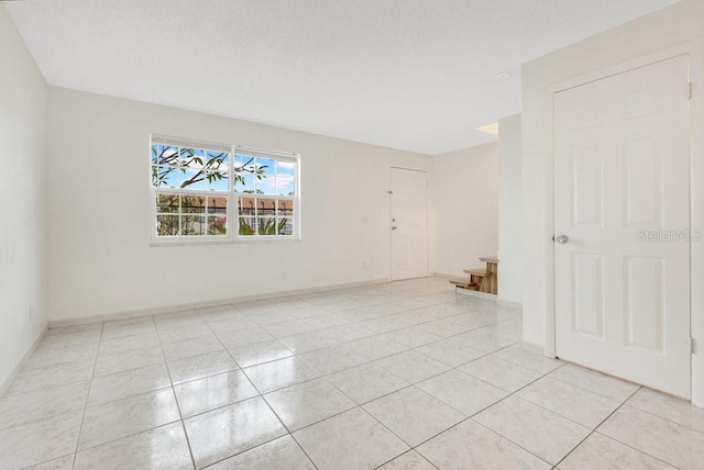 5763 Saint Christopher Dr Unit 55, Orlando, FL 32822 - spare room featuring light tile patterned floors, baseboards, and a textured ceiling