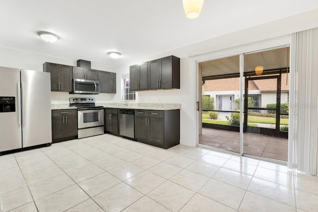5763 Saint Christopher Dr Unit 55, Orlando, FL 32822 - kitchen featuring stainless steel appliances, light tile patterned floors, and light stone counters