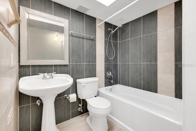 5763 Saint Christopher Dr Unit 55, Orlando, FL 32822 - full bathroom featuring bathing tub / shower combination, visible vents, toilet, a sink, and tile walls