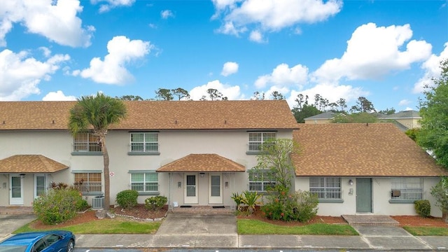 5763 Saint Christopher Dr Unit 55, Orlando, FL 32822 - back of property featuring central AC, roof with shingles, and stucco siding