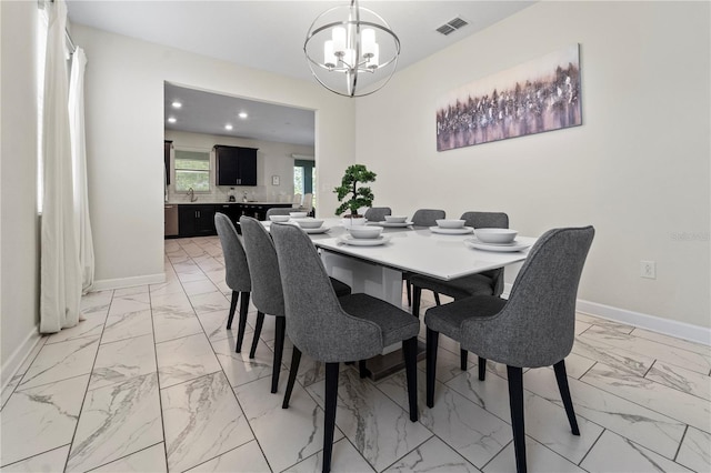 dining space featuring light marble finish flooring, a chandelier, and baseboards