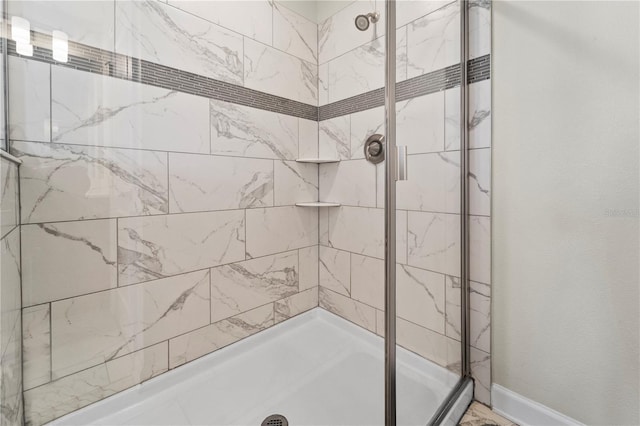 bathroom featuring a shower stall and baseboards