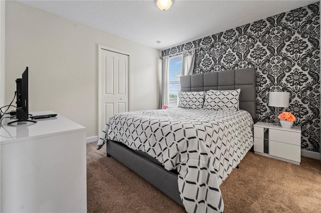 bedroom featuring light colored carpet, baseboards, and a closet