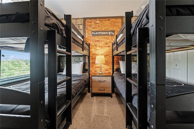 unfurnished bedroom featuring carpet flooring and brick wall