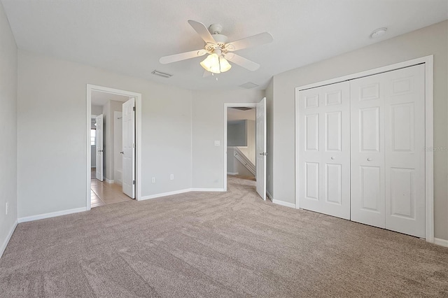 unfurnished bedroom featuring visible vents, baseboards, a closet, and light colored carpet