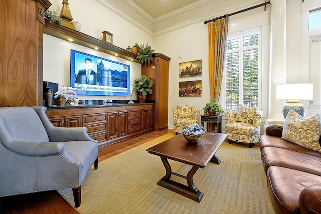 sitting room with crown molding, baseboards, and wood finished floors