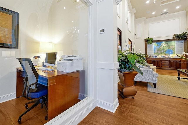 office featuring baseboards, ornamental molding, wood finished floors, and visible vents
