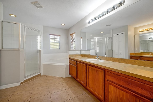 bathroom featuring tile patterned floors, a stall shower, a bath, and visible vents