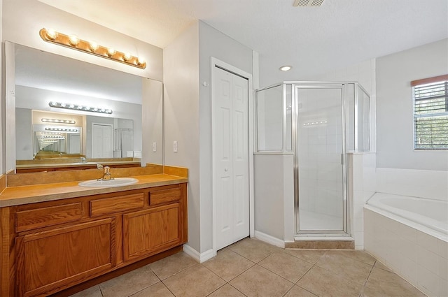 full bathroom featuring vanity, tile patterned flooring, a stall shower, and a garden tub